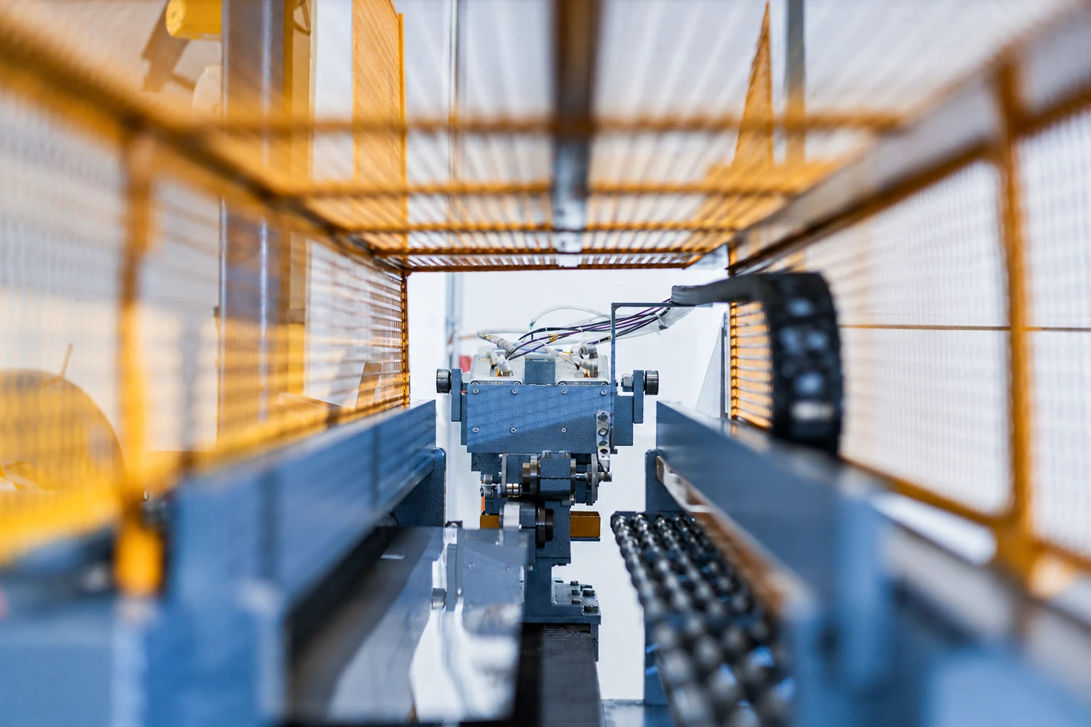 Schneidkopf der CNC-Anlage zwischen gelben Schutzgittern bei MECO-TECH.